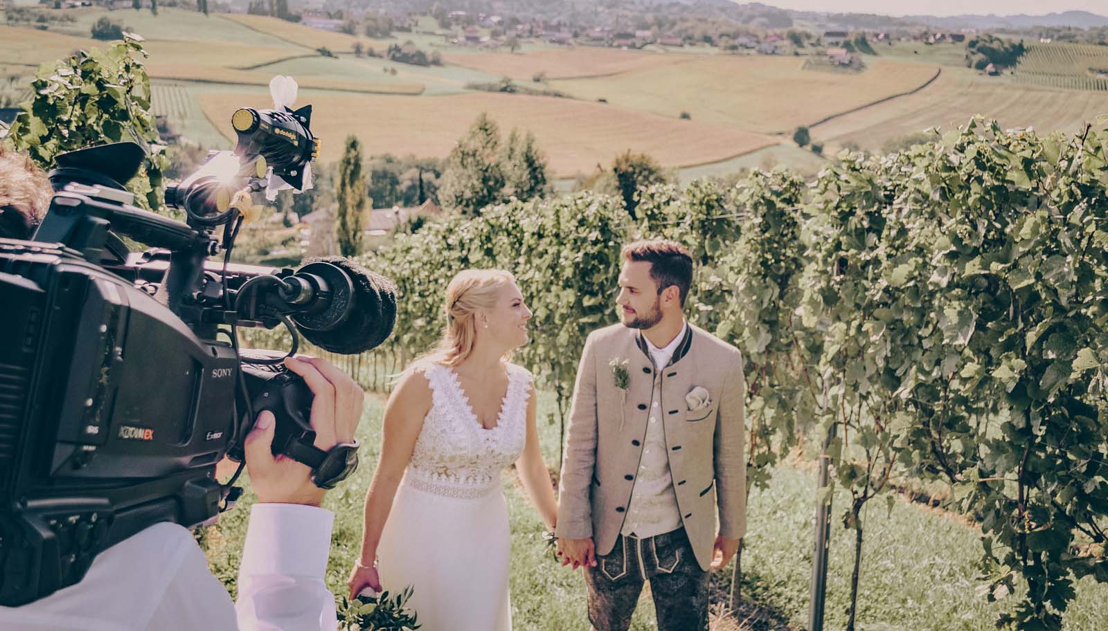 Brautpaar geht Weingarten Hand in Hand hinauf und wir dabei gefilmt für ein Hochzeitsvideo